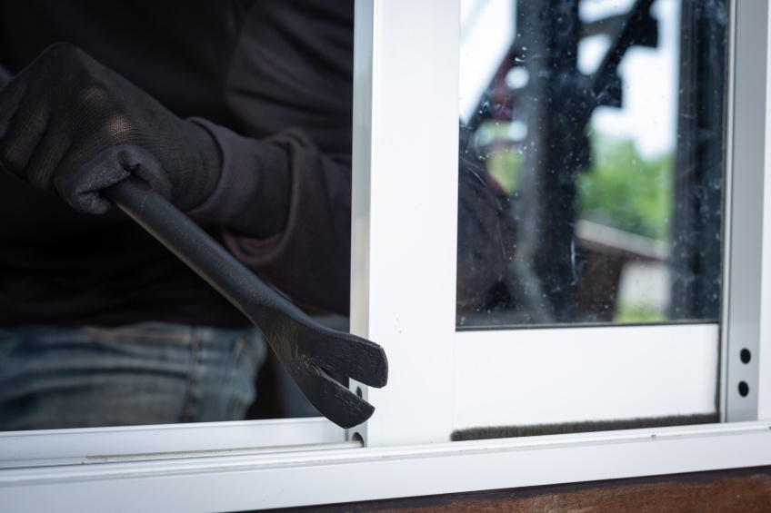 burglar with crowbar trying to break-in through window